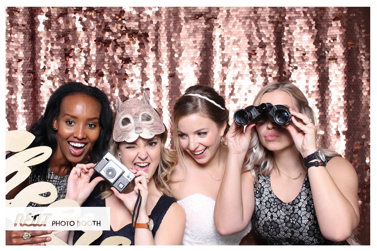 A group of women at a wedding using a photo booth